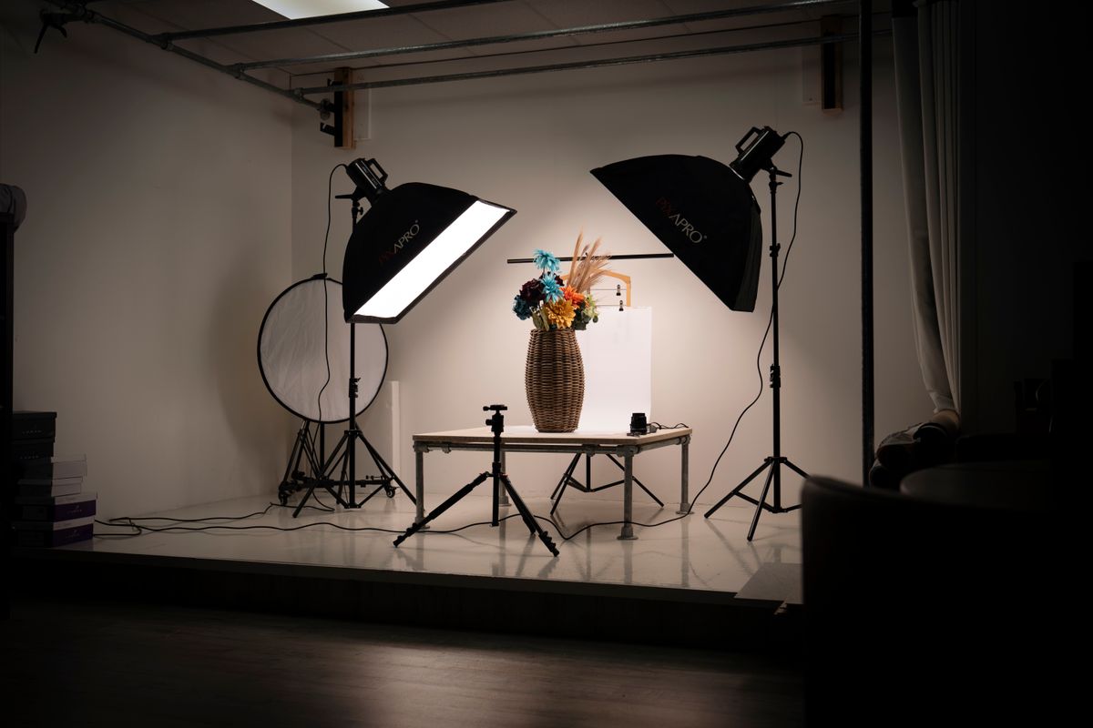 Een binnenstudio met verlichting en een bloemstuk in een mand. Ideaal voor studiofotografie.